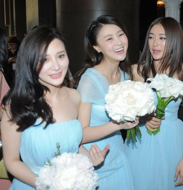 Phù dâu nổi bật trong làn váy xanh với bó hoa trắng thanh khiết.