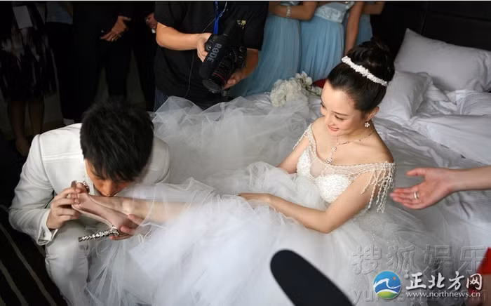 Chú rể thể hiện tình yêu và sự trân trọng bằng cách hôn lên chân cô dâu. Ảnh: northnews