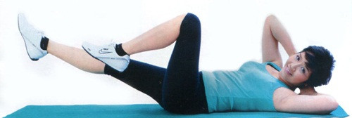 Động tác 5: - Nằm thẳng 2 tay đặt sau đầu. - Nâng một đầu gối lên 45 độ, chân kia duỗi thẳng nâng cao và vận động như động tác đạp xe đạp. - Cùng lúc nâng vai trái và phải để khuỷu tay này chạm gối kia. Lặp lại 20 lần.