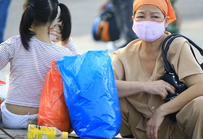 Hai bà cháu mệt mỏi chờ được tuyến xe bus đúng lịch trình