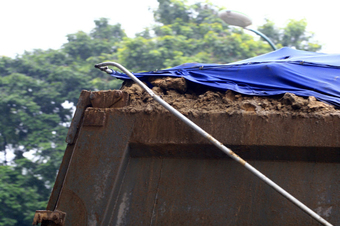 Che đậy sơ sài nên những chiếc xe tải này có thể văng đất đá xuống đường bất kì lúc nào Che đậy sơ sài nên những chiếc xe tải này có thể văng đất đá xuống đường bất kì lúc nào