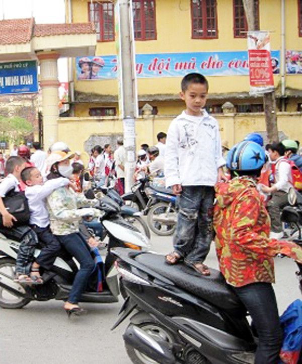 Trẻ nhỏ cũng biết... làm xiếc trên xe máy của bố mẹ Trẻ nhỏ cũng biết... làm xiếc trên xe máy của bố mẹ