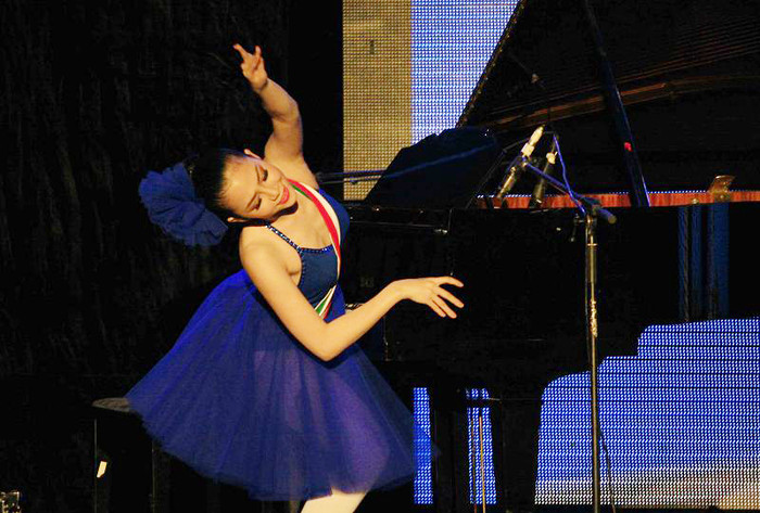 Trong trang phục xanh mang màu cờ Italia, Linh Nga rất sang trọng bên đàn Piano