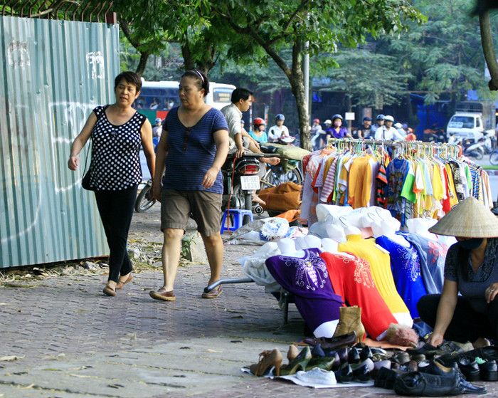 Người đi bộ len lỏi giữa đống hàng Người đi bộ len lỏi giữa đống hàng