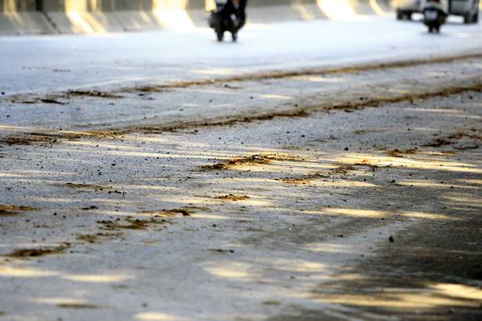 Mặt đường Phạm Văn Đồng nhiều đoạn vương vãi đất cát do xe tải chở đất, cát để lại sau mỗi lần rơi vãi Mặt đường Phạm Văn Đồng nhiều đoạn vương vãi đất cát do xe tải chở đất, cát để lại sau mỗi lần rơi vãi