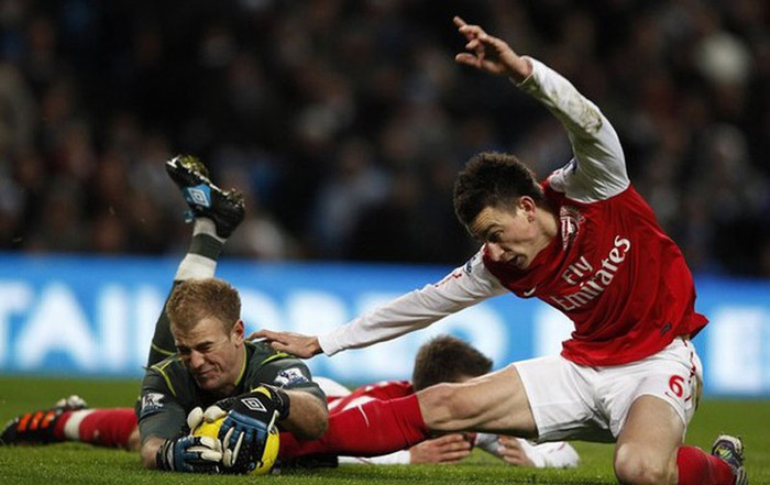 Joe Hart dũng cảm bắt gọn bóng trước pha lao vào "quyết tử" của Laurent Koscielny Joe Hart dũng cảm bắt gọn bóng trước pha lao vào "quyết tử" của Laurent Koscielny