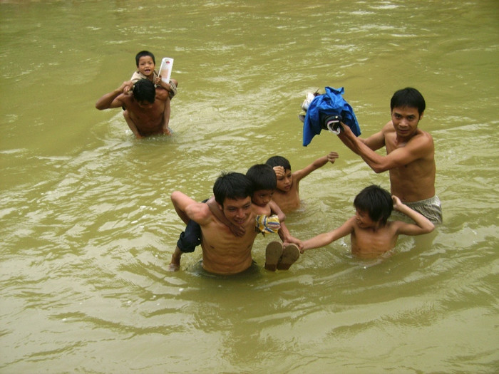 Những học sinh mẫu giáo, lớp 1, lớp 2 thi được cõng trên lưng còn những em lớn hơn phải bám theo các thầy để vượt qua suối sâu Những học sinh mẫu giáo, lớp 1, lớp 2 thi được cõng trên lưng còn những em lớn hơn phải bám theo các thầy để vượt qua suối sâu