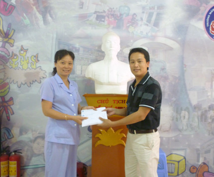 Bà Đinh Thúy Hiền, đại diện lãnh đạo trường Mầm non thực hành Hoa Hồng trao tiền và vật phẩm cho ông Bùi Ngọc Cải, Phó Tổng biên tập báo điện tử Giáo dục Việt Nam.