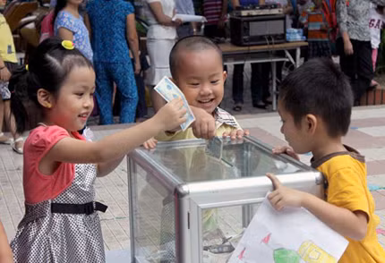 Các học sinh mẫu giáo trường Mầm non thực hành Hoa Hồng ủng hộ tiền trong đợt phát động quyên góp “Bữa cơm có thịt”