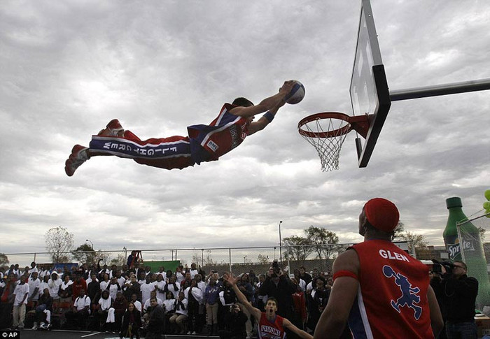 Một nam sinh trường trung học bay người thực hiện cú slam dunk trong trận đấu ở giải bóng rổ trung học Một nam sinh trường trung học bay người thực hiện cú slam dunk trong trận đấu ở giải bóng rổ trung học