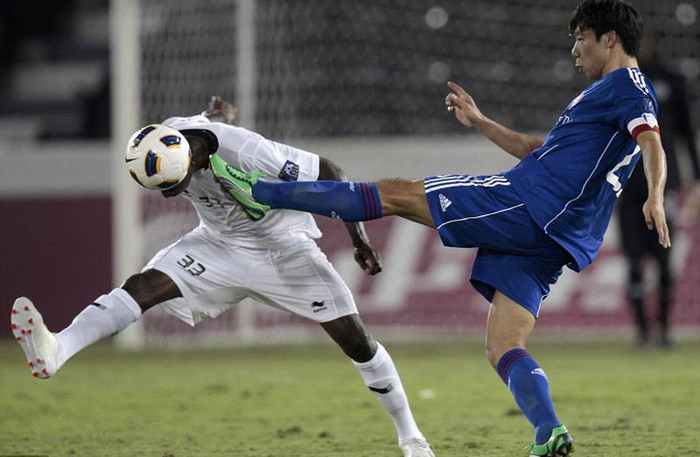 Mohammed Kassola (trái) của Al Saad dũng cảm tranh bóng với Yeom Ki Hun của Suwon Bluewings trong trận bán kết Champions League châu Á ở Doha, Qatar