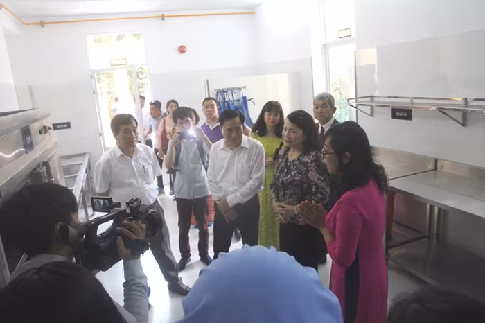 Tiến sĩ Nguyễn Thị Nghĩa, Thứ trưởng Bộ Giáo dục và Đào tạo cùng các đại biểu đi thăm quan mô hình Bếp ăn mẫu bán trú tại Trường tiểu học Hoàng Văn Thụ (Lạng Sơn). Ảnh: Minh Chí.