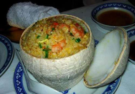 3. Cơm Dừa – Bến Tre Để được món cơm dừa ngon phải mất gần hai giờ đồng hồ. Những trái dừa xiêm được cắt ngang một phần trên đầu quả dừa trút hết nước ra và dùng miếng cắt đó như nắp để đậy 'quả cơm' lại.