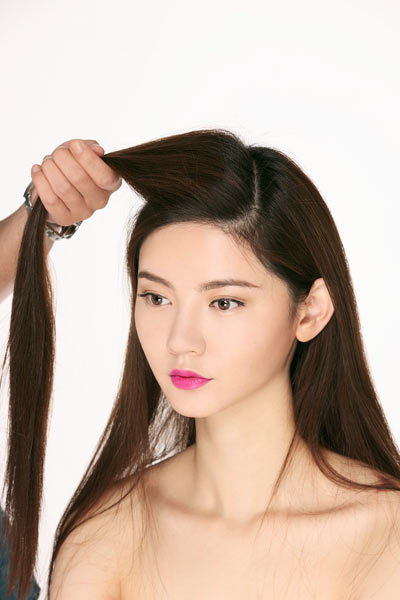 Chia tóc lệch ngôi, lấy phần tóc trên đỉnh đầu tách ra.