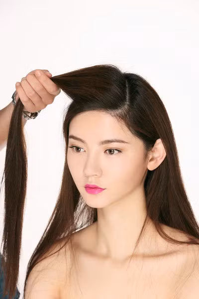 Chia tóc lệch ngôi, lấy phần tóc trên đỉnh đầu tách ra.