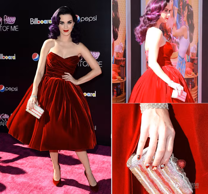 Katy Perry đồng bộ với váy đỏ giày đỏ gợi cảm cùng chiếc ví như một hộp quà dễ thương.