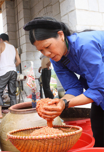 Ở khu phục vụ ăn uống của người Nùng (Lục Ngạn, Bắc Giang). Chị Lý Thị Oi (54 tuổi) luôn chân, luôn tay đãi gạo, đồ xôi 3 màu. Màu đỏ làm từ lá cẩm, màu vàng từ nghệ và màu tím đen từ cây sau. Theo chị, làm xôi 3 màu rất mất thời gian vì phải vào rừng lấy lá rồi giã, ngâm, nấu rất lâu. Chính vì vậy món ăn này chỉ dùng vào ngày tết Thanh Minh.