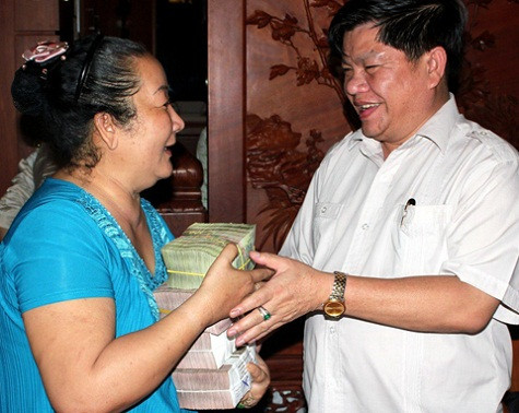 Một nông dân nuôi cá vui vẻ nhận tiền từ tay chồng bà Hiền. Ảnh: T.P