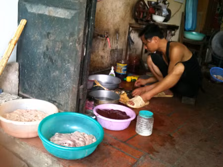 Người bán hàng này bày lòng ra chậu, không che đậy để ruồi bâu tự nhiên, không những thế người này còn làm gà ở nền gạch gần cống nước Ảnh Dan tri.