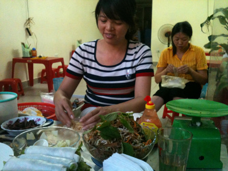 Dùng tay trần cuốn nem, phở cho khách, chốc chốc chị lại nhận tiền, trả tiền thừa cho khách rồi lại tiếp tục cuốn nem Ảnh Dan tri. Dùng tay trần cuốn nem, phở cho khách, chốc chốc chị lại nhận tiền, trả tiền thừa cho khách rồi lại tiếp tục cuốn nem Ảnh Dan tri.