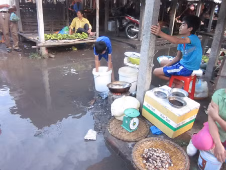 Rùng mình với cảnh người bán hang đang rán chảo bánh ngay trên vũng nước. Chỉ cần xe máy đi qua là nước bẩn có thể té lên chảo bánh này.