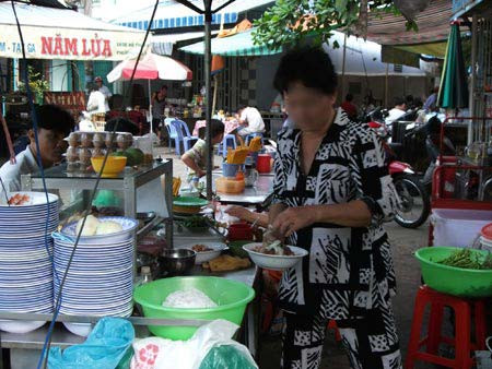 Người bán hàng thản nhiên dùng tay bốc đồ ăn để bán cho khách. (Ảnh 24h). Người bán hàng thản nhiên dùng tay bốc đồ ăn để bán cho khách. (Ảnh 24h).