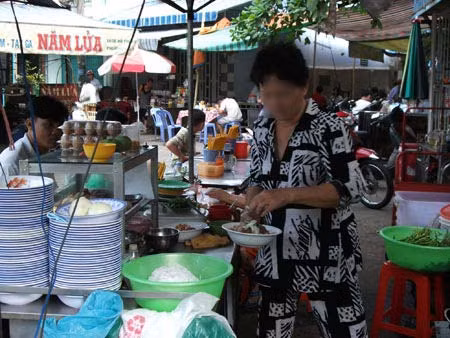 Người bán hàng thản nhiên dùng tay bốc đồ ăn để bán cho khách. (Ảnh 24h).