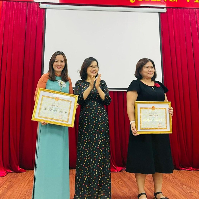 Cô Nguyễn Thị Sông Thương (bìa trái), Hiệu trưởng trường Trung học cơ sở Nguyễn An Ninh thay mặt nhà trường nhận Bằng khen Cô Nguyễn Thị Sông Thương (bìa trái), Hiệu trưởng trường Trung học cơ sở Nguyễn An Ninh thay mặt nhà trường nhận Bằng khen