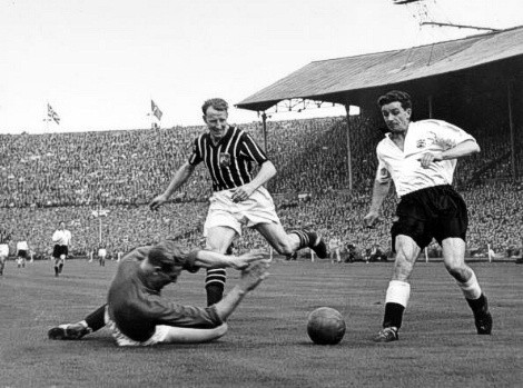 Trautmann, bất chấp bị đau ở cổ sau pha va chạm trước đó, vẫn dũng cảm lao tới để chụp bóng trước pha băng tới của Peter Murphy (phải), khiến ông va chạm mạnh với đồng đội Dave Ewing (áo sọc) và bất tỉnh lần thứ hai Trautmann, bất chấp bị đau ở cổ sau pha va chạm trước đó, vẫn dũng cảm lao tới để chụp bóng trước pha băng tới của Peter Murphy (phải), khiến ông va chạm mạnh với đồng đội Dave Ewing (áo sọc) và bất tỉnh lần thứ hai