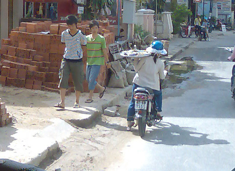 Đi xe máy, một tay bê mâm mỳ Quảng, chụp tại Hội An. Ảnh: Trần Huyền Đi xe máy, một tay bê mâm mỳ Quảng, chụp tại Hội An. Ảnh: Trần Huyền