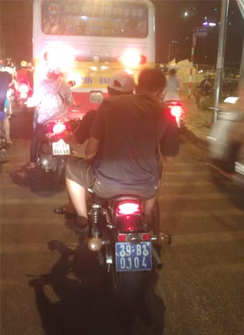 Chạy xe "biển xanh" không đội mũ bảo hiểm. Ảnh: Tony Trần