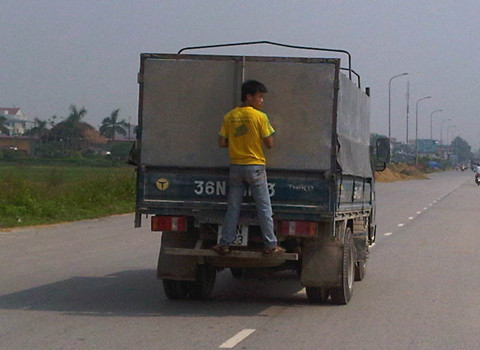 Chàng trai bám sau đuôi xe tải (Ảnh: Như Trưng). Chàng trai bám sau đuôi xe tải (Ảnh: Như Trưng).