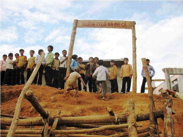 Cổng lên trường thì dốc hơn đỉnh núi, không có đường mòn lên, phải trèo núi. Cổng chỉ là mấy khúc gỗ ghép thành hình như cổng thành thời... Tam Quốc
