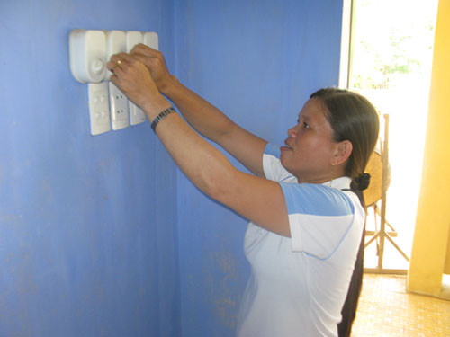Cô Huỳnh Thị Thịnh đang kiểm tra công tắc điện bị trục trặc