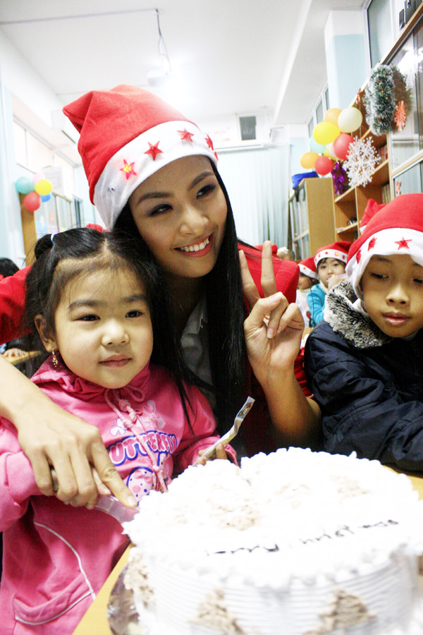 Tranh thủ tại dáng bên bánh mừng Giáng sinh Tranh thủ tại dáng bên bánh mừng Giáng sinh