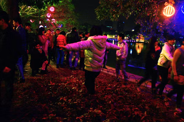 Không chụp được ảnh ở vườn hoa, các bạn trẻ còn nhảy hắn vào giữa các luống hoa ven hồ Gươm