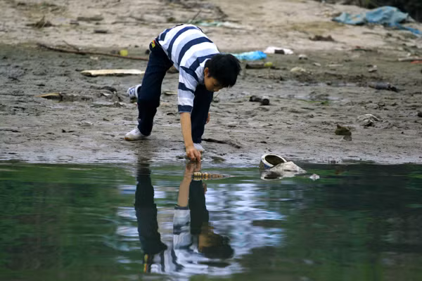 Trong khi nhiều đứa trẻ đang nằm trong chăn ấm đệm êm thì các em bé ở bãi giữa vẫn đang đối mặt với giá rét và sự nguy hiểm thường trực của sông Hồng.