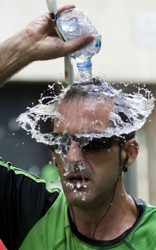 Một VĐV điền kinh tự dội nước vào đầu trước khi bước lên vạch xuất phát