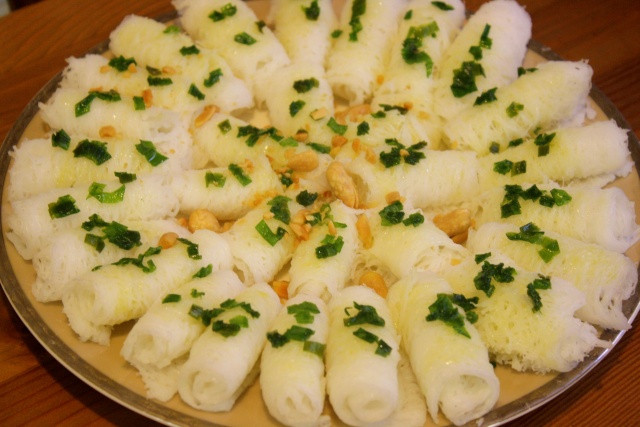 5. Bánh hỏi Khởi thủy là bánh xổi, hấp nóng hổi vừa thổi vừa ăn, lâu ngày biến thành bánh hỏi. Bánh hỏi làm bằng bột gạo, phải chọn gạo lúa cũ đem xay lấy bột rồi 'sú' để qua đêm cho bột nở đều. Sau đó đem nhồi thành từng khối lớn hình bầu dục, gọi là 'vặn', nặng chừng một ký. 5. Bánh hỏi Khởi thủy là bánh xổi, hấp nóng hổi vừa thổi vừa ăn, lâu ngày biến thành bánh hỏi. Bánh hỏi làm bằng bột gạo, phải chọn gạo lúa cũ đem xay lấy bột rồi 'sú' để qua đêm cho bột nở đều. Sau đó đem nhồi thành từng khối lớn hình bầu dục, gọi là 'vặn', nặng chừng một ký.