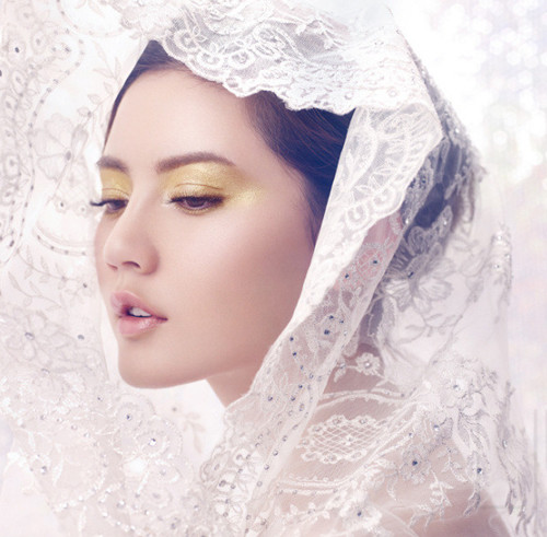 Với những cô dâu lãng mạn, hãy thử trang trí cho tóc với kiểu khăn voan trùm khá lạ mắt. Phần trang điểm mắt cũng được tạo điểm nhấn với gam vàng nhũ