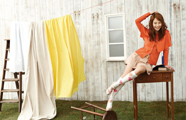 Áo sơ mi được thiết kế giống như áo cape, có cầu vai màu cam, mix cùng chân váy ngắn màu nude trông cũng rất mới mẻ, dành cho những bạn gái xì-tin.