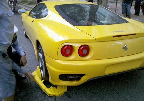 Siêu xe Ferrari 360 đỗ sai luật và không có biển số trên một con phố ở Quảng Châu (Trung Quốc), bằng đấy lỗi đủ để nó bị "cùm chân". Nhưng viên cảnh sát giao thông này đã có một ngày không mấy suôn sẻ khi chiếc khóa càng của Trung Quốc quá nhỏ so với chiếc bánh của siêu xe. Ảnh: Carnewschina. Siêu xe Ferrari 360 đỗ sai luật và không có biển số trên một con phố ở Quảng Châu (Trung Quốc), bằng đấy lỗi đủ để nó bị "cùm chân". Nhưng viên cảnh sát giao thông này đã có một ngày không mấy suôn sẻ khi chiếc khóa càng của Trung Quốc quá nhỏ so với chiếc bánh của siêu xe. Ảnh: Carnewschina.