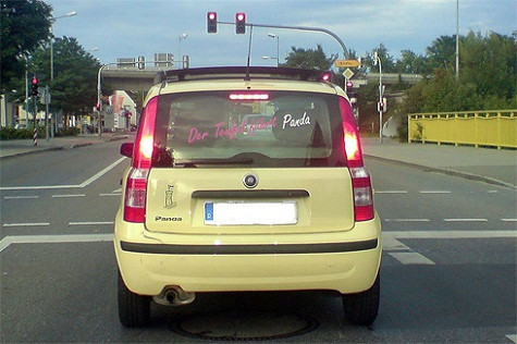 Trên kính hậu của chiếc Fiat Panda màu vàng là dòng chữ: "Quỷ dữ lái Panda". Trên kính hậu của chiếc Fiat Panda màu vàng là dòng chữ: "Quỷ dữ lái Panda".