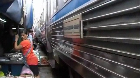 Một chủ hàng nép mình khi chuyến tàu đi qua.