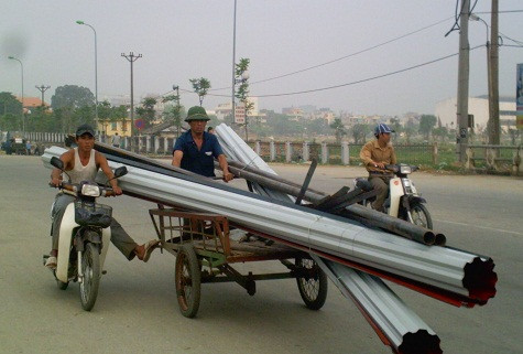Lại thêm một kiểu quá liều nữa. Với sự hỗ trợ của xe mô tô, chiếc xe ba gác lao đi vun vút, hãy thử tưởng tượng xem điều gì sẽ xảy ra nếu chiếc xe chở những tấm tôn sắc lẹm kia va phải ai đó đang đi trên đường. Ảnh chụp tại Cầu Đông Hương, Đại lộ Lê Lợi, TP Thanh Hoá Lại thêm một kiểu quá liều nữa. Với sự hỗ trợ của xe mô tô, chiếc xe ba gác lao đi vun vút, hãy thử tưởng tượng xem điều gì sẽ xảy ra nếu chiếc xe chở những tấm tôn sắc lẹm kia va phải ai đó đang đi trên đường. Ảnh chụp tại Cầu Đông Hương, Đại lộ Lê Lợi, TP Thanh Hoá