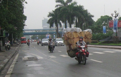 Hàng chiếm hết chỗ rồi, để em… ngồi tạm gác xe thôi vợ nhé! Đường Nguyễn Chí Thanh, Hà nội. Hàng chiếm hết chỗ rồi, để em… ngồi tạm gác xe thôi vợ nhé! Đường Nguyễn Chí Thanh, Hà nội.