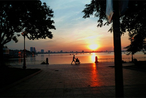 Hoàng hôn trên hồ Tây, Hà Nội. Cháu bé đẩy xe lăn đi dạo cùng ông. Hoàng hôn trên hồ Tây, Hà Nội. Cháu bé đẩy xe lăn đi dạo cùng ông.