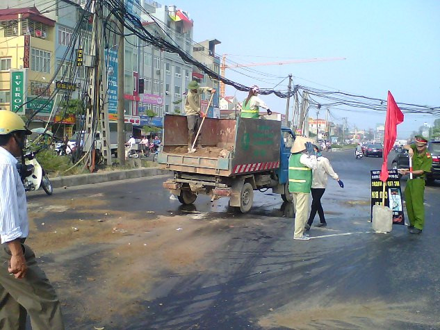 Công nhân môi trường đô thị mất nhiều công để dập vết dầu loang không rõ "thủ phạm" để lại.