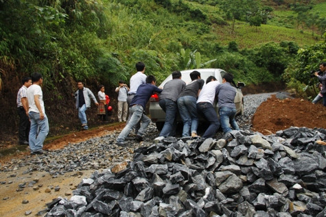 Đoàn công tác đặc biệt phải đẩy từng chiếc xe qua đoạn đường đèo dốc, lổn nhổn đá