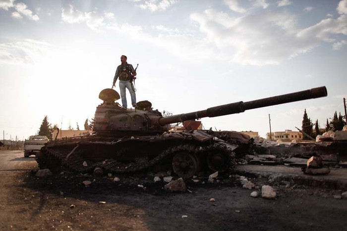 Syria (10/9): Một thành viên thuộc Lực lượng Quân đội Tự do Syria trên một chiếc xe tăng bị phá hủy của quân đội Syria. Syria (10/9): Một thành viên thuộc Lực lượng Quân đội Tự do Syria trên một chiếc xe tăng bị phá hủy của quân đội Syria.